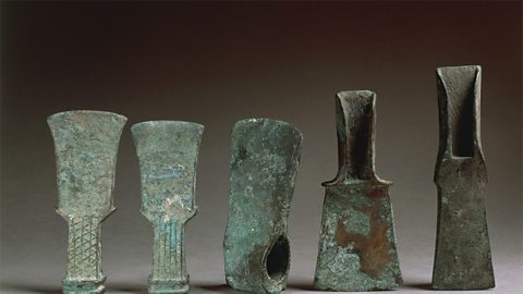 A historic collection of axes showing copper oxidising to a green colour (verdigris).