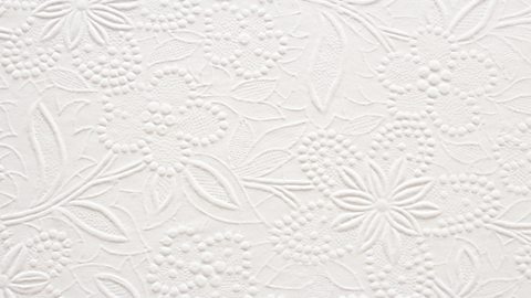 A close-up segment of an embossed floral pattern on white paper.