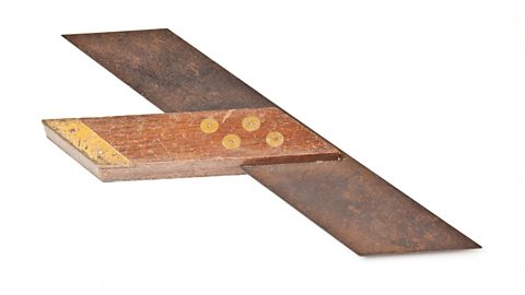 A dark T-shaped mitre square isolated on a white background.