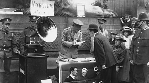 Photograph of a man giving his name to an officer at a recruitment drive in Trafalgar Square during World War One