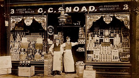 A photograph of two grocers outside their shop front in World War One