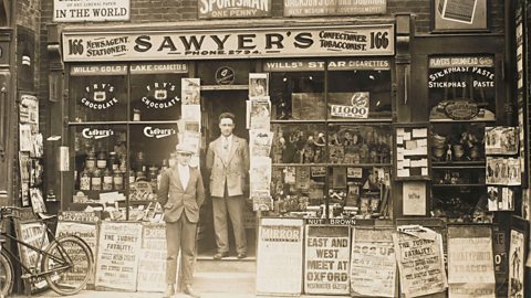 A photograph of two newsagents outside their shop front soon after World War One