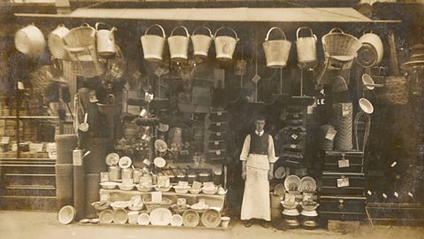 A photograph of an ironmonger outside his shop front in World War One