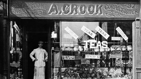 A photograph of a confectioner outside his shop front in World War One