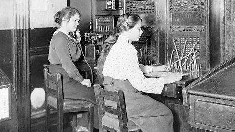 Two women operate a telephone exchange switchboard during World War One