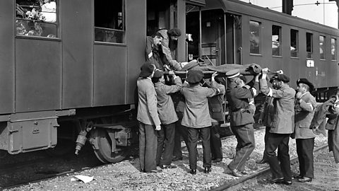 World War One ambulance train workers unload injured soldiers from the train