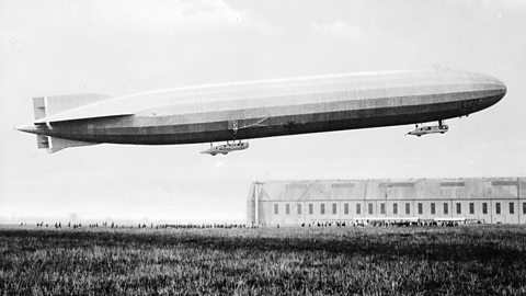 A German Zeppelin airship in flight above an air field