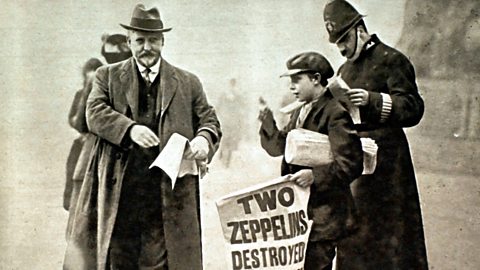 A child on a street selling newspapers to passers-by during World War One