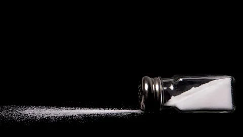 A salt cellar lying on its side with salt spilling out (Credit: Getty Images)