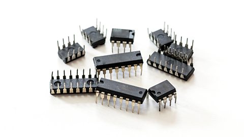 A collection of black microcontrollers of varying sizes and length of pins.