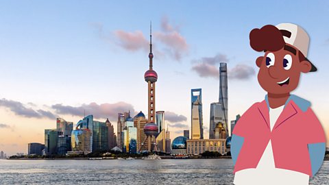 A boy standing next to some skyscrapers in Shanghai