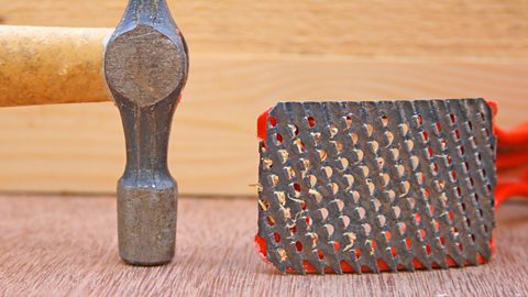 A tool similar to a cheese grater, called a surform and used to shape timber, is shown.