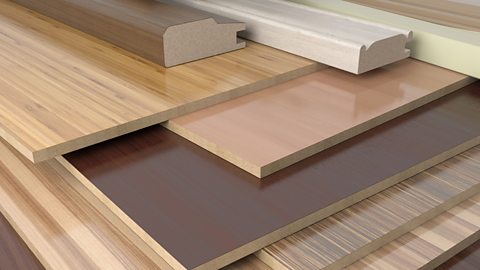 A pile of manufactured boards, veneered with a variety timbers with a gloss finish.