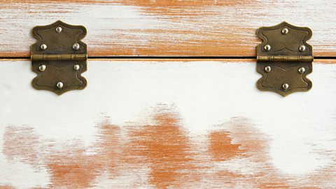 Two brass butterfly hinges use six screws each to hold a lid onto a painted wooden box.