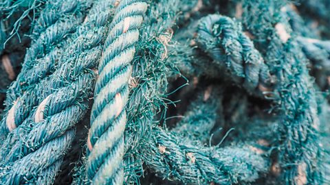 A close-up of slightly fraying blue rope made from nylon.