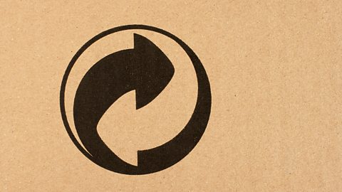 The European recycling symbol of two arrows curved around each other on a cardboard box.