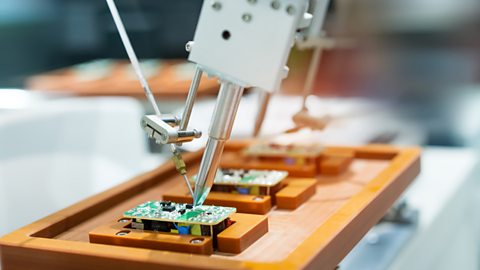 An automated machine adds intricate solder to a tiny circuit board.