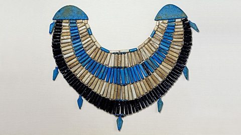 A photo of a blue, white and purple beaded wide collar necklace