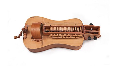 A Hurdy gurdy - a stringed instrument played by a hand turned wheel.