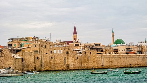 Acre fortress on the seafront with fishing vessels