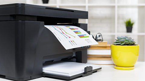 A laser printer in an office, colour printing a statistics document.