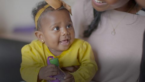 Baby girl smiling at song.