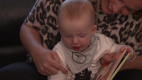 Austin enjoying looking at a book with his mum.