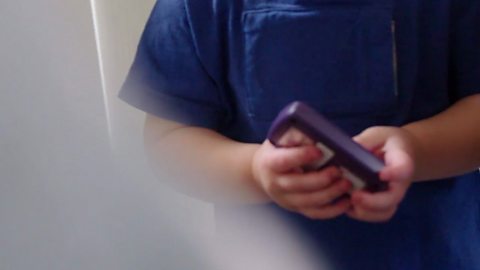 Toddler Percy holding the LENA device