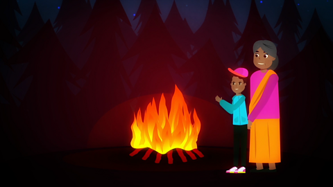 A boy and his grandma beside a bonfire.