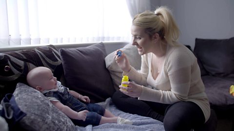 A mum talking to her baby about blowing bubbles.