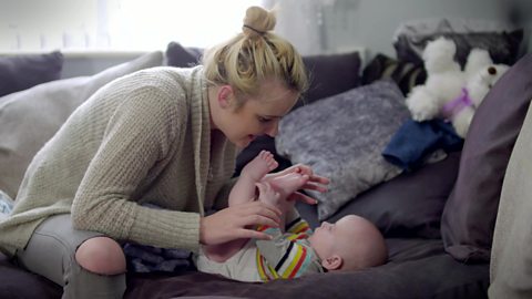 A mum touching her baby son's feet.