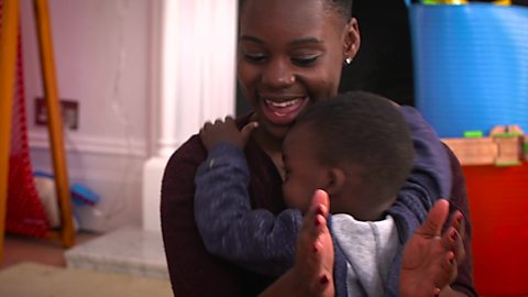 A mum singing and clapping to her son.