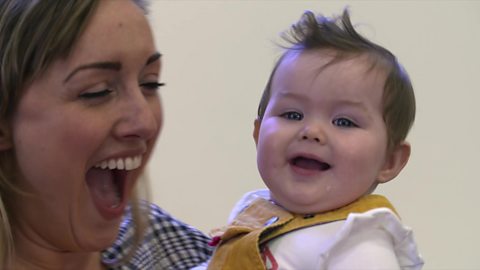 Mum dancing with her baby and smiling