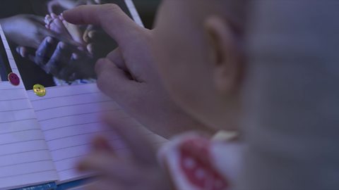 A baby looking at a photo book