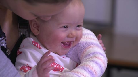 Mum tickling baby with a sock puppet