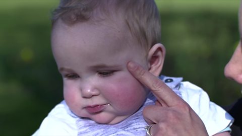 Mum pointing at baby's eyes