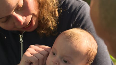 Mum pointing at baby's ears