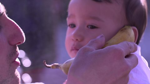 Baby using a banana as a phone