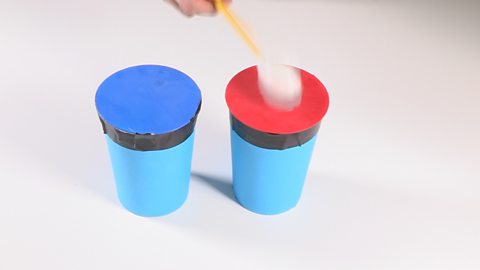 The two drums being played with a tissue covered pencil.