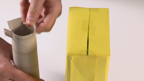 Folding down the tabs made in the tube.