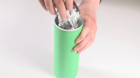 Hands placing the foil in a snack tube.