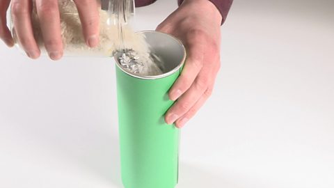 Rice being poured into the tube with the foil.