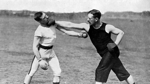 Two fighters demonstrate a boxing move.