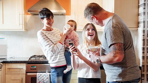 A mum and dad in a kitchen with two children