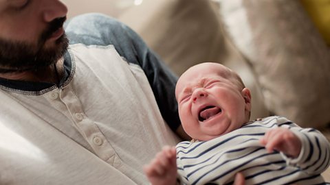 Man holding crying baby