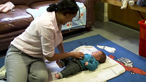 A mum playing with her baby down on the floor