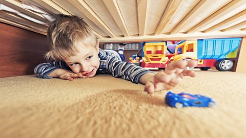 Boy reaching for a toy car