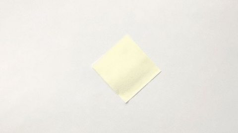 A yellow square of paper on a white background.