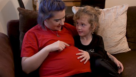 A little girl with her pregnant mum.