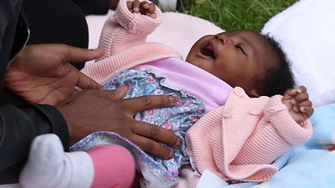 A baby girl being tickled.